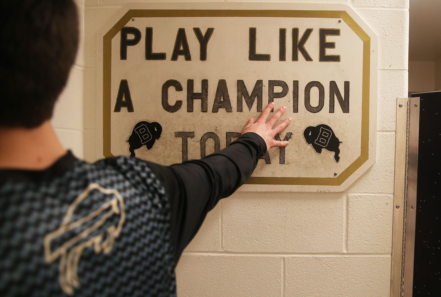 Each of the varsity players taps the sign